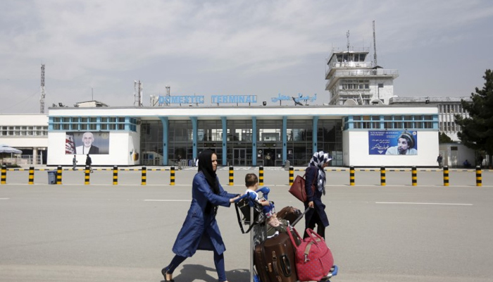 Afghan passengers walk in front of Hamid Karzai International Airport in Kabul, Afghanistan March 29, 2016.— Reuters/File