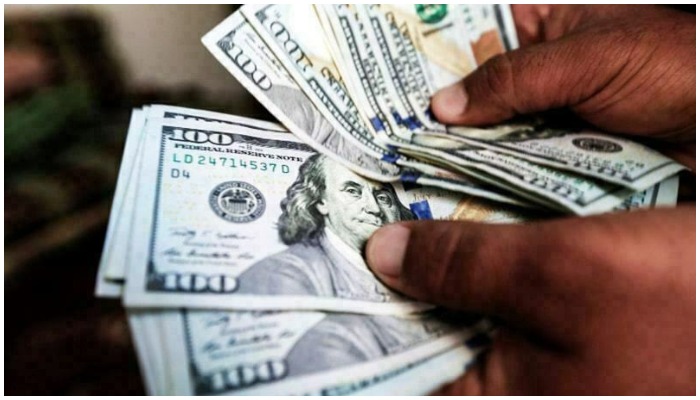 A file photo of a man counting US dollar bills. Photo: AFP