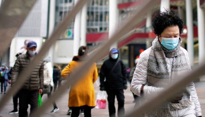 Orang-orang yang memakai masker wajah setelah wabah penyakit coronavirus (COVID-19) berjalan di jalan perbelanjaan di Shanghai, Cina, 14 Desember 2021. — Reuters/File