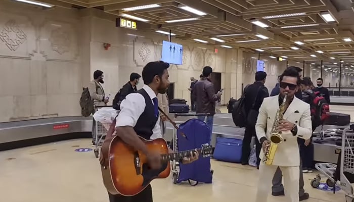 A musical duo play traditional jingle bells at the Jinnah International Airport in Karachi. — Facebook