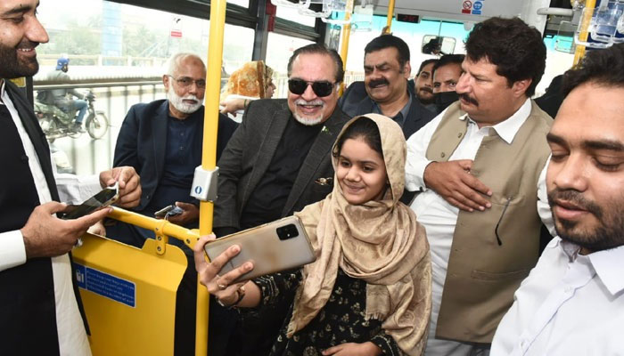 Governor Sindh Imran Ismail smiles for a selfie as he takes a ride on board the Green Line bus, in Karachi, on December 5, 2021. — Twitter/Imran Ismail