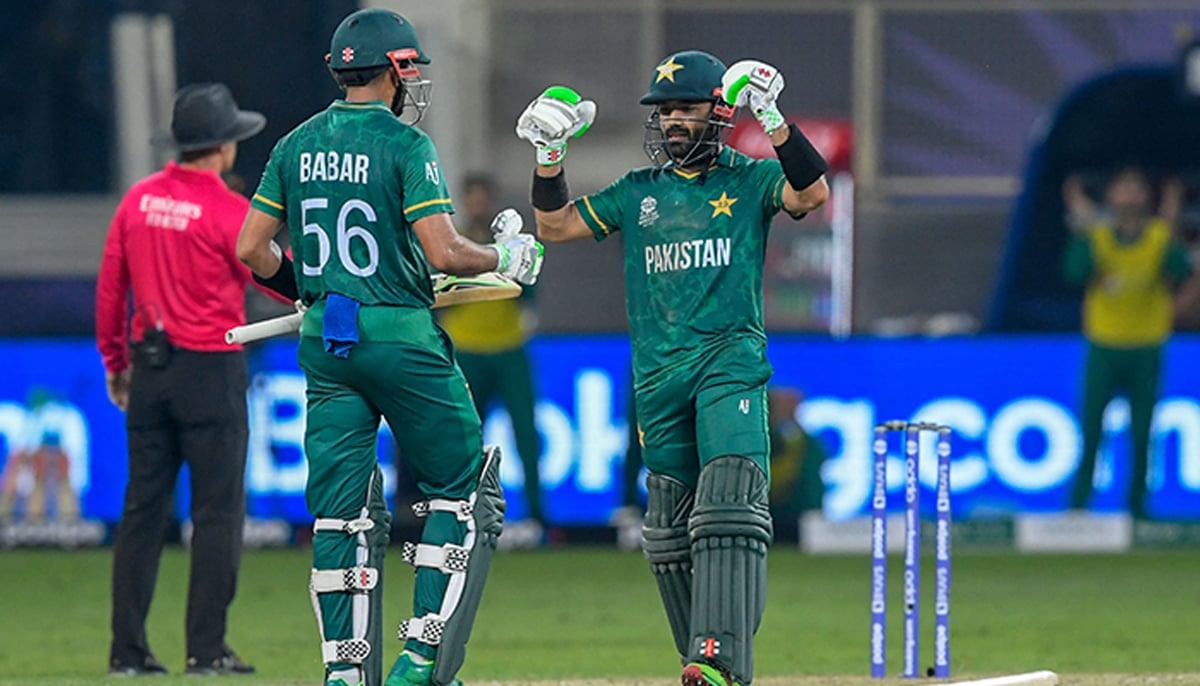 Pakistan´s Mohammad Rizwan (R) celebrates after scoring a half-century (50 runs) as his team captain Babar Azam applauds during the ICC T20 World Cup cricket match between India and Pakistan at the Dubai International Cricket Stadium in Dubai on October 24, 2021. — AFP