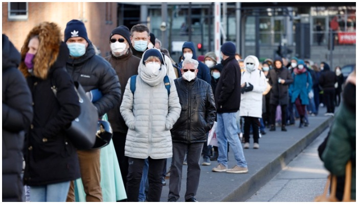 People wearing face masks queue to get vaccinated in the Philharmonic Hall in the northern German city of Hamburg. — AFP/File