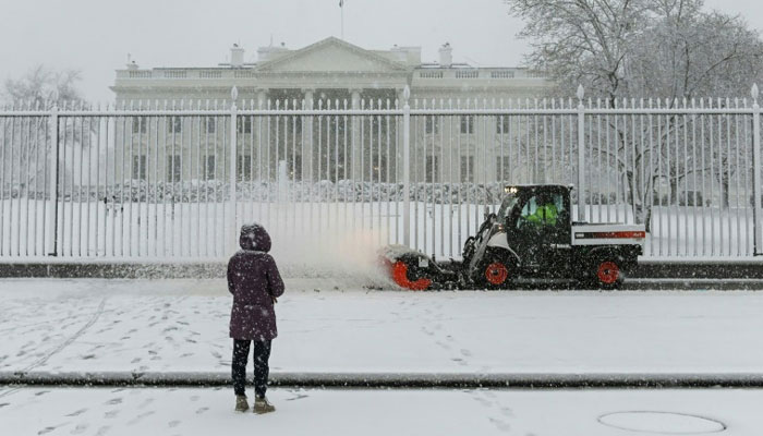Snow is being cleared outside the White House in Washington, DC on January 3, 2022. Agencies
