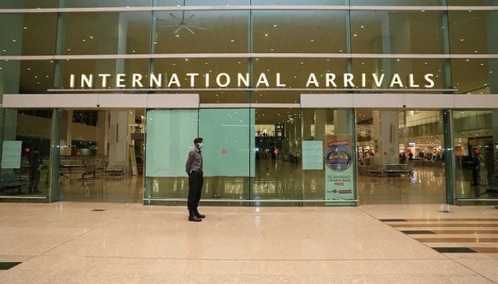 Airport Security Force (ASF) personnel wearing a mask stand guard at the international arrivals area at Islamabad Airport.— Photo: Ministry of Overseas Pakistanis & HRD/Twitter