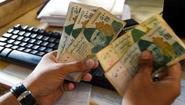 A man counting Pakistani rupees. Photo— AFP/File