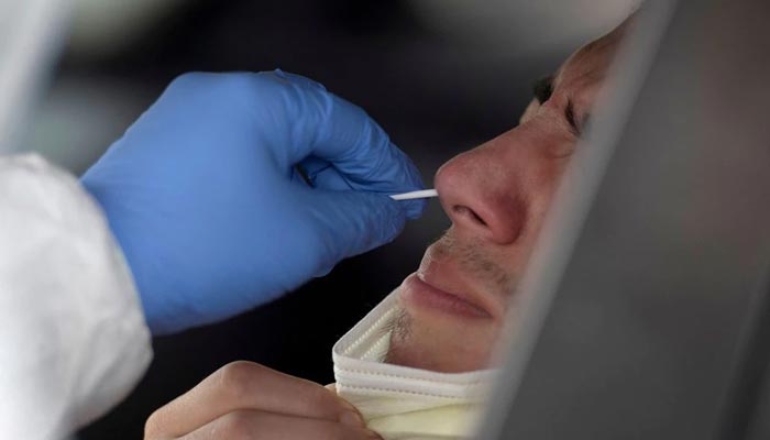 Seorang pria diusap hidungnya ketika orang-orang menunggu di kendaraan mereka dalam antrean panjang untuk pengujian penyakit virus corona (COVID-19) di Houston, Texas, AS, 7 Juli 2020. —Reuters/File