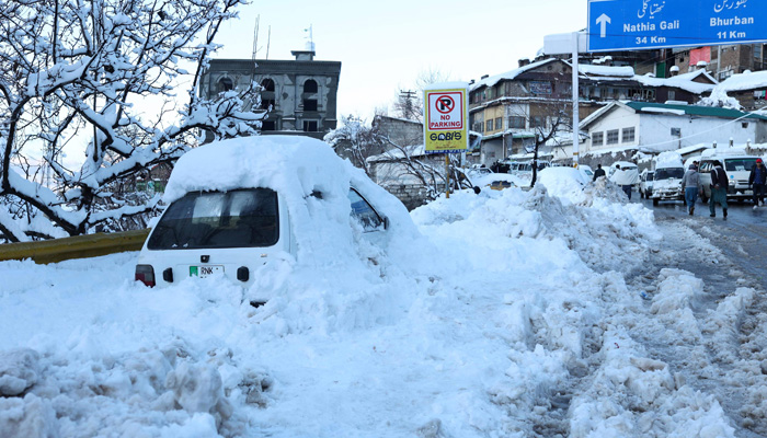 A vehicle is pictured after getting stuck in snow along a road after a heavy snowfall in Murree, around 70 kilometres (45 miles) northeast of the capital, Islamabad on January 8, 2022 after an incident earlier where at least 21 people died in an enormous traffic jam caused by tens of thousands of visitors thronging to a the hill town to see unusually heavy snowfall. — Photo by AFP