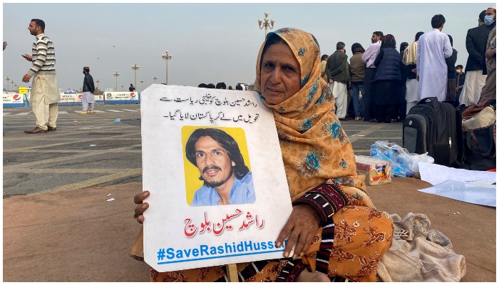 Baz Khatoon, 60, sits with a photo of her son, along with others demanding to know the details on the wheareabouts of their missing family members, in Islamabad, Pakistan February 19, 2021. — Reuters