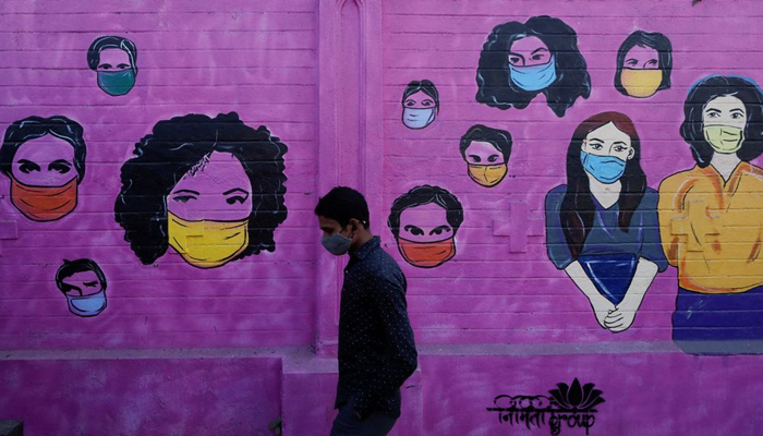 A man wearing a protective face mask walks past a mural on a street, amidst the spread of the coronavirus disease (COVID-19), in Mumbai, India, January 10, 2022. — Reuters