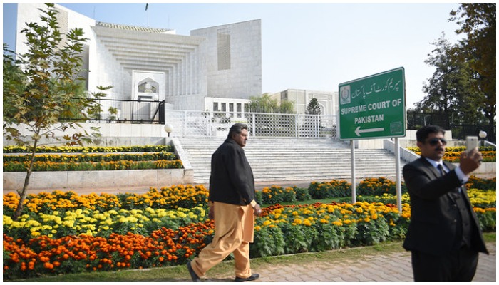 A Pakistani lawyer (R) uses his mobile phone in front of the Supreme Court building in Islamabad on November 28, 2019. — AFP/File