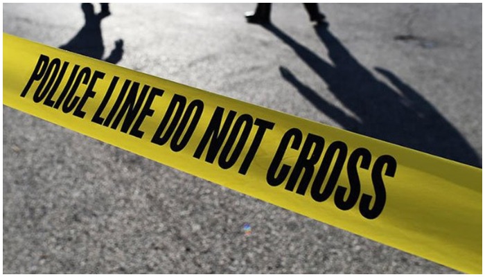 Police officials stand behind crime scene tape.  — AFP/File
