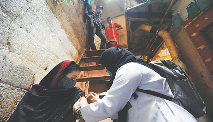 A healthcare worker administers a COVID-19 vaccine dose during a door-to-door campaign in a slum in Karachi, on 13, 2022.—Reuters/File