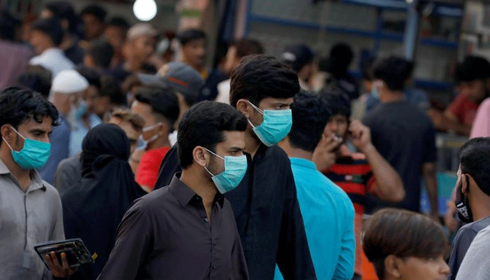 Men wearing protective face masks walk amid the rush of people outside a market as the outbreak of the coronavirus disease (COVID-19) continues, in Karachi, Pakistan June 8, 2020. — Reuters/File