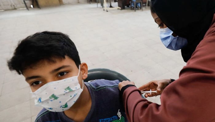 Hussain Mustafa, 13, receives his first dose of the coronavirus disease (COVID-19) vaccine at a vaccination centre in Karachi, Pakistan, January 3, 2022. — Reuters/File