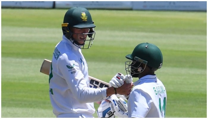 Pemain Afrika Selatan Rassie van der Dussen (kiri) merayakan 50 pertandingan lari bersama pemain Afrika Selatan Temba Bavuma (kanan) pada hari keempat pertandingan kriket Uji ketiga antara Afrika Selatan dan India di stadion Newlands di Cape Town pada 14 Januari 2022. — Rodger Bosch/AFP)
