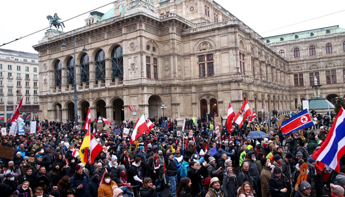 Demonstrators hold flags and placards as they march to protest against COVID-19 restrictions and the vaccine mandate in front of the State Opera in Vienna, Austria. Agencies