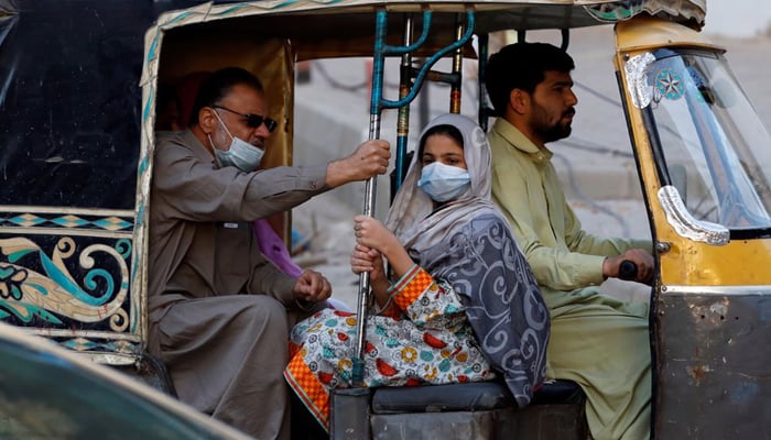 People with masks against COVID-19 travel by rickshaw (tuk tuk) in Karachi, Pakistan January 25, 2021. — Reuters/File