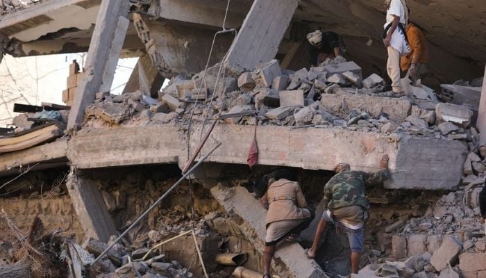 Rescuers search for survivors under the collapsed roof of a house hit by Saudi-led air strikes in Sanaa, Yemen, January 18, 2022. Photo: Reuters