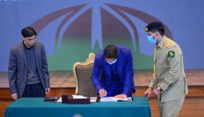 Prime Minister Imran Khan signs public version of National Security Policy (NSP). Photo: Prime Minister Office Twitter.