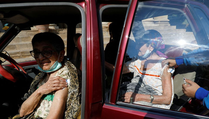 Women receive coronavirus disease (COVID-19) booster vaccine outside a vaccination centre in Karachi, Pakistan, January 7, 2022. — Reuters/File