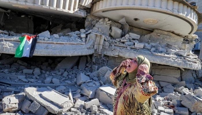 A Palestinian woman reacts after Israeli forces bulldozed Montaser Shalabis home in Turmusayya, near Ramallah, in the occupied West Bank. —AFP