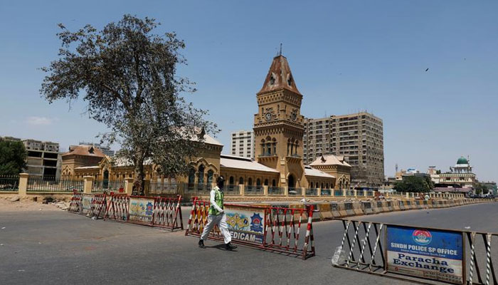 A traffic police officer walks past barriers used to block the road in front of the British era Empress Market building, during a lockdown after Pakistan shut all markets, public places and discouraged large gatherings amid an outbreak of coronavirus disease (COVID-19), in Karachi, Pakistan April 3, 2020. — Reuters/File