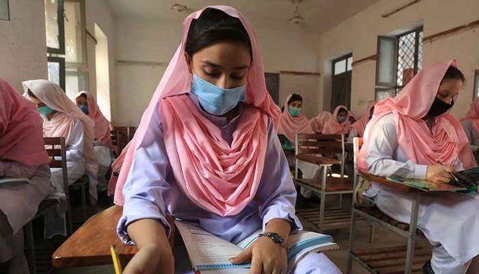Siswa memakai masker pelindung menjaga jarak aman saat mereka menghadiri kelas, setelah pemerintah mengizinkan pembukaan kembali sekolah dari kelas enam hingga delapan di tengah pandemi penyakit coronavirus (COVID-19), di Peshawar, Pakistan 23 September 2020. Foto: Reuters
