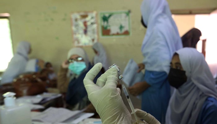 A health worker administers the COVID-19 vaccine to students at a government school in Karachi, on January 14, 2022. Photo: PPI
