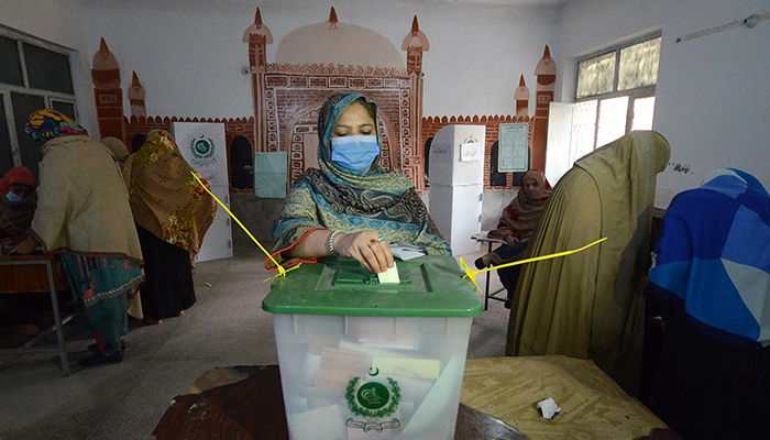 A woman casts her vote at Begum Shahbudin School polling station during the first phase of the local government election in Peshawar, on December 19. 2021. — INP/File