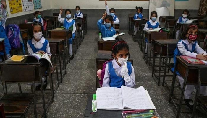 Image of students, wearing masks, sitting in a classeoom — AFP