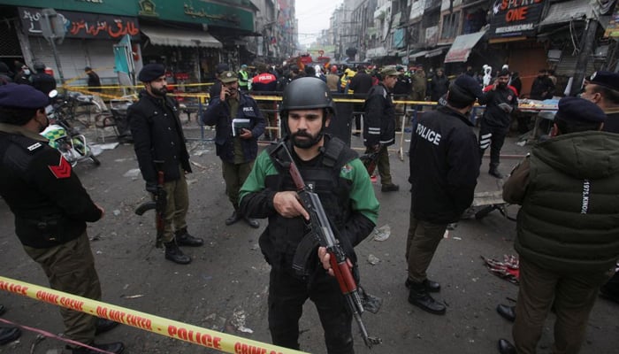 Police officers stand guard inside a cordoned area after a blast in a market, in Lahore, Pakistan January 20, 2022. — Reuters