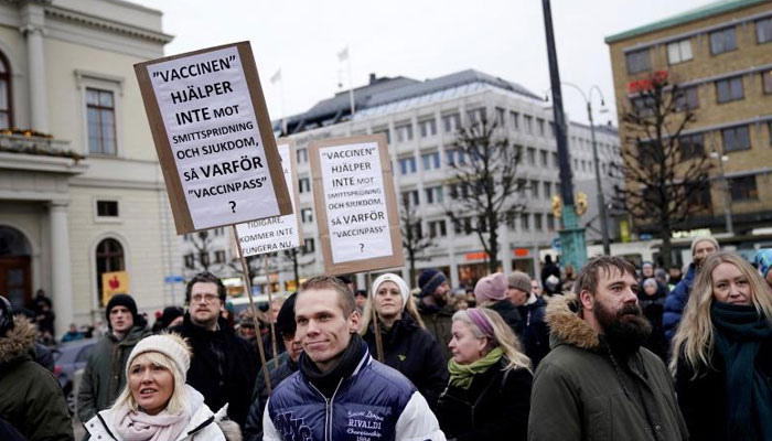 A protester holds up a sign reading, The vaccine does not help against the spread of infection and disease, so why vaccine passes? in Gothenburg. Agencies