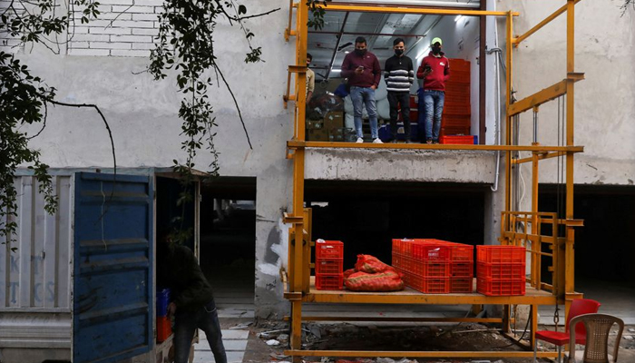 A man unloads groceries from a vehicle at a dark store of the SoftBank-funded Blinkit, an Indian company which is offering 10 minute deliveries for groceries, in New Delhi, India, January 19, 2022. Picture taken on January 19, 2022. — Reuters