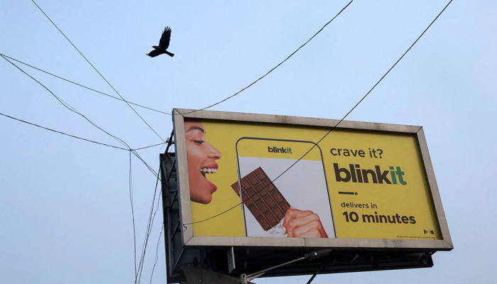 A bird flies over a hoarding featuring an advertisement of the SoftBank-funded Blinkit, an Indian company which is offering 10 minute deliveries for groceries, in New Delhi, India, January 20, 2022. Picture taken on January 20, 2022. — Reuters