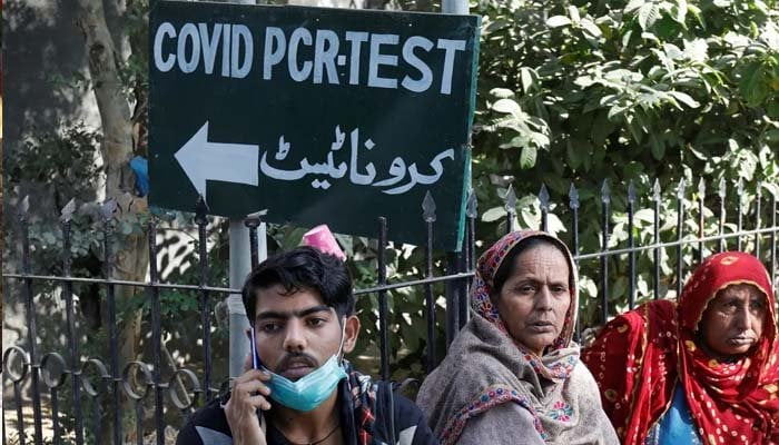 People sitting outside a COVID-19 PCR testing facility. Photo: Geo.tv/ file