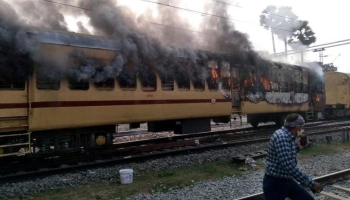 Smoke comes out from a trains carriage after angry mobs set it on fire in Gaya in the eastern Indian state of Bihar [AFP]