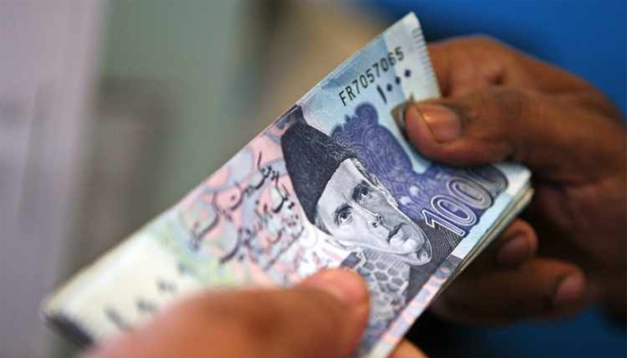 Currency dealers can be seen exchanging Rs1,000 notes. — AFP/File