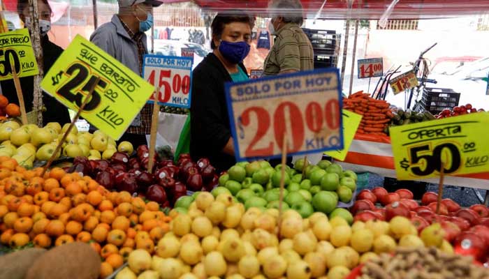 Customers walk past a fruit stall at a street market, in Mexico City, Mexico December 17, 2021.— Reuters/File