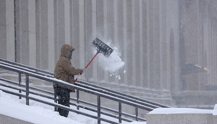 A person clears stairs of snow during a Noreaster storm in Manhattan, New York City, US, January 29, 2022. — Reuters