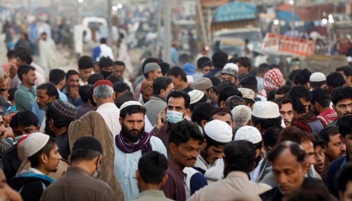 A man wearing a protective mask walks through a crowd of people along a makeshift market as the outbreak of the coronavirus continues, in Karachi, January 17. — Reuters/File