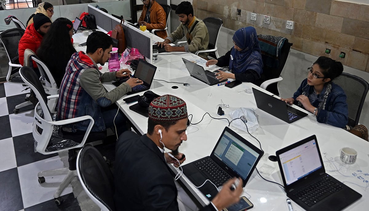 In this picture taken on January 8, 2022, employees of Taza Transforming Agriculture talk with customers at a call centre in Lahore. — AFP