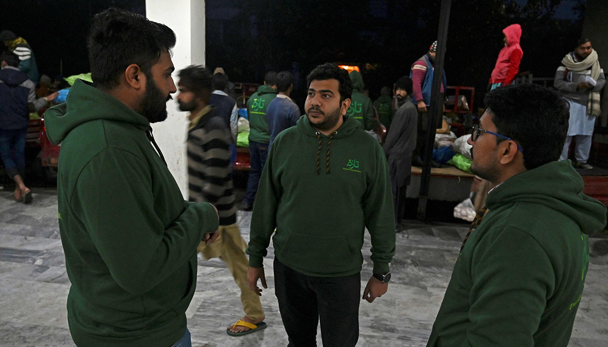 In this picture taken on January 8, 2022, team members of Taza Transforming Agriculture gather at vegetable distributing point in Lahore. — AFP