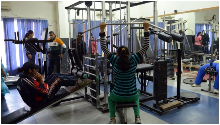 Female kabaddi athletes working out in a gym — AFP