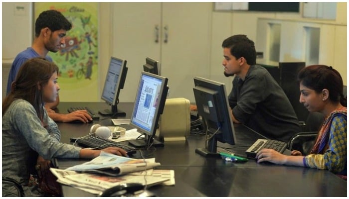 Image showing men and women working in an office space — AFP