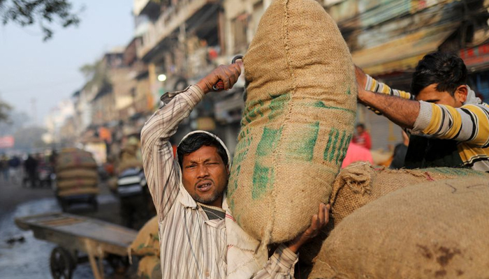 A labourer reacts as he carries a sack at a wholesale market in the old quarters of Delhi, India, January 31, 2022. — Reuters