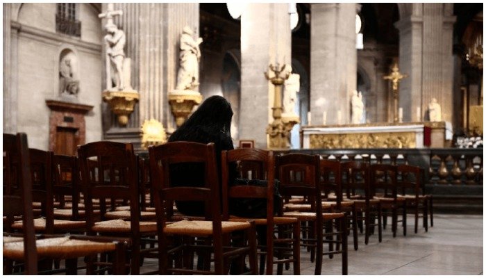 Representational image of a woman praying inside a church — AFP
