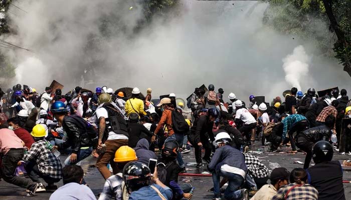 Protesters react after police fired tear gas during a demonstration against the military coup in Mandalay on March 3. Photo– AFP