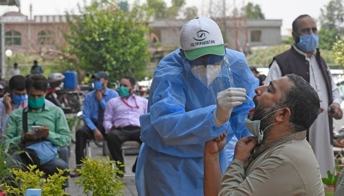 Health worker conducting a PCR test for coronavirus in Pakistan. Photo: AFP