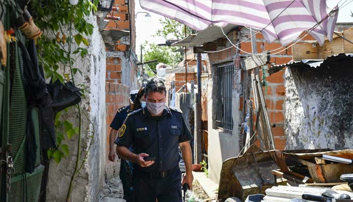 Police raid a slum in a suburb of Buenos Aires in connection with multiple deaths caused by ingesting cocaine laced with an unknown toxic substance. Photo– Eliana OBREGON /AFP